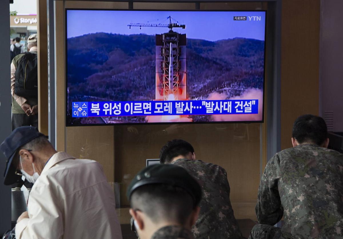 Varias personas ven las noticias ​​en Seúl sobre que Corea del Norte lanzará un satélite espía militar a principios de junio