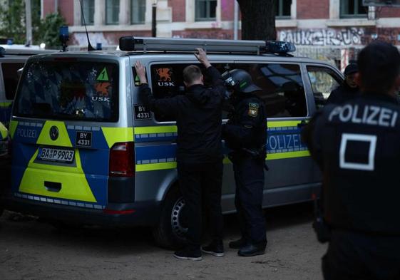 Un agente antidisturbios procede a la detención de uno de los radicales.