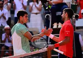 Carlos Alcaraz y Novak Djokovic se saludan tras la victoria del serbio en semifinales de Roland Garros.