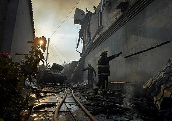 Rescatistas observan los destrozos causados por un bombardeo ruso en Jersón.