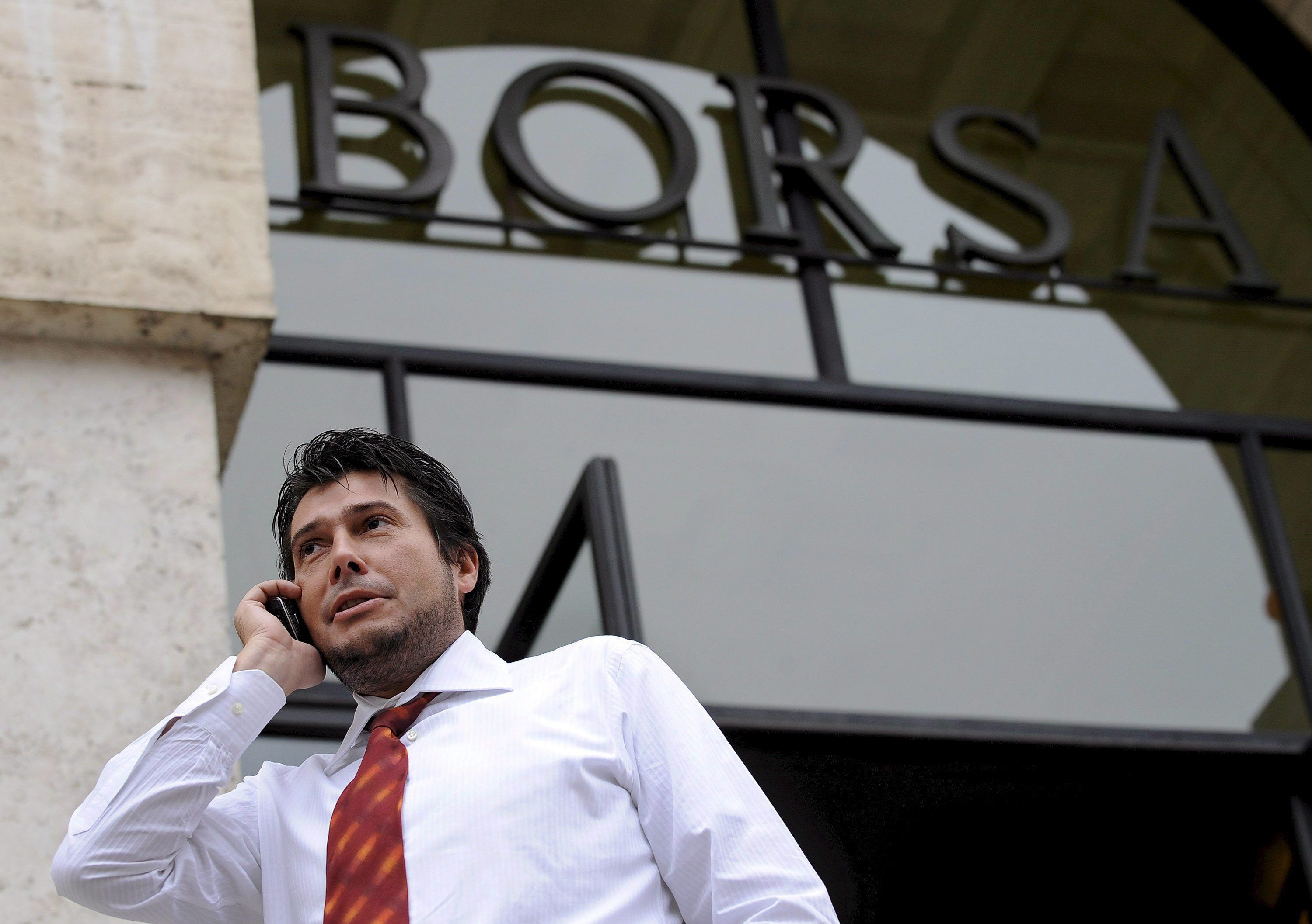 Un broker habla por teléfono frente al edificio de Piazza Affari.