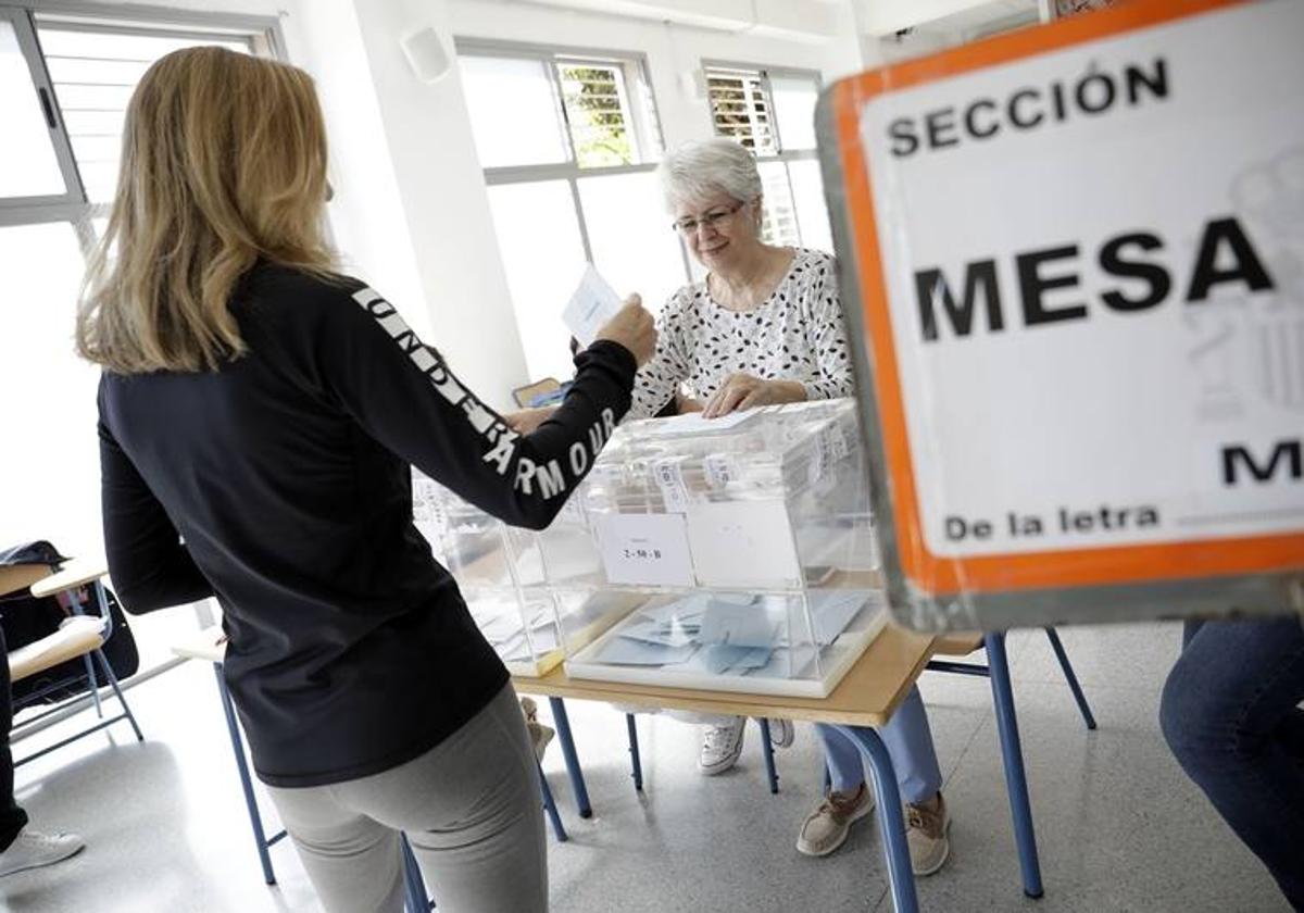 Una votante deposita su papeleta en una urna durante unas elecciones