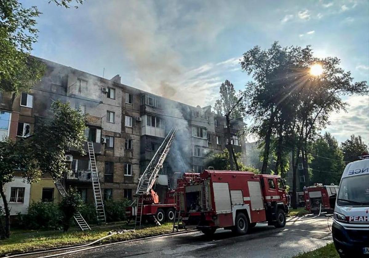 Un camión de bomberos trabaja en la extinción del incendio provocado en un edificio residencial de Krivói Rog