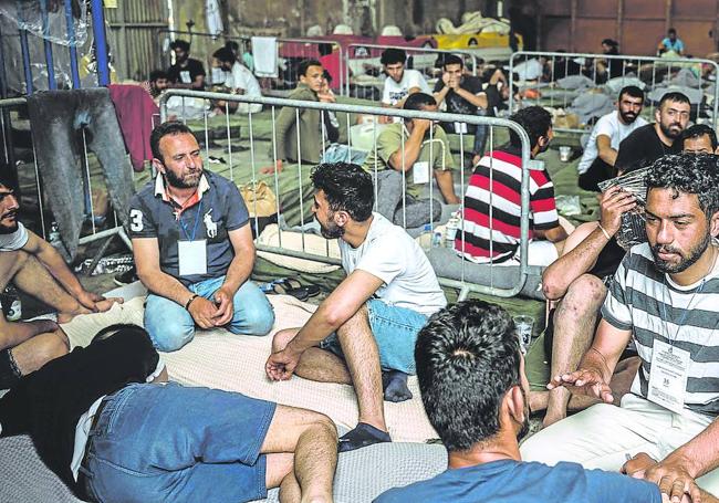 Supervivientes del naufragio descansan en un antiguo almacén del puerto de Kalamata, en la región griega del Peloponeso.