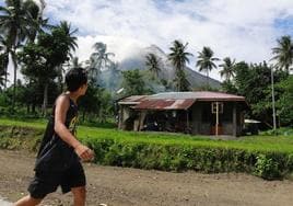 Un niño mirá el volcán desde una aldea cercana.