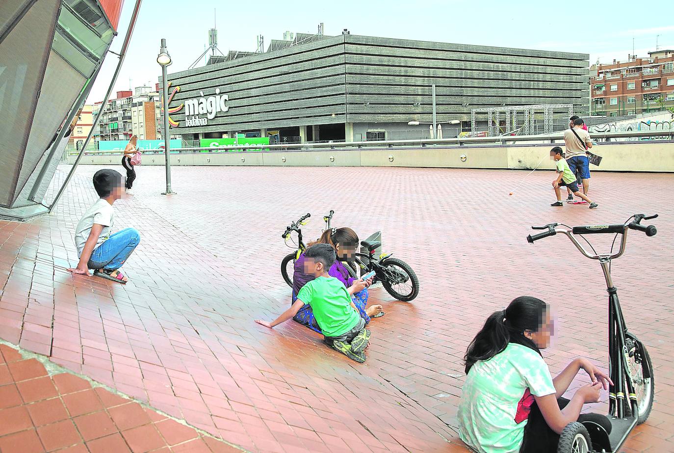 Niños juegan en las inmediaciones del centro comercial en el que se han registrado varias agresiones.