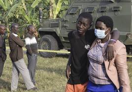Un alumno de la escuela atacada el viernes por las ADF en Uganda llora la muerte de más de cuarenta compañeros.