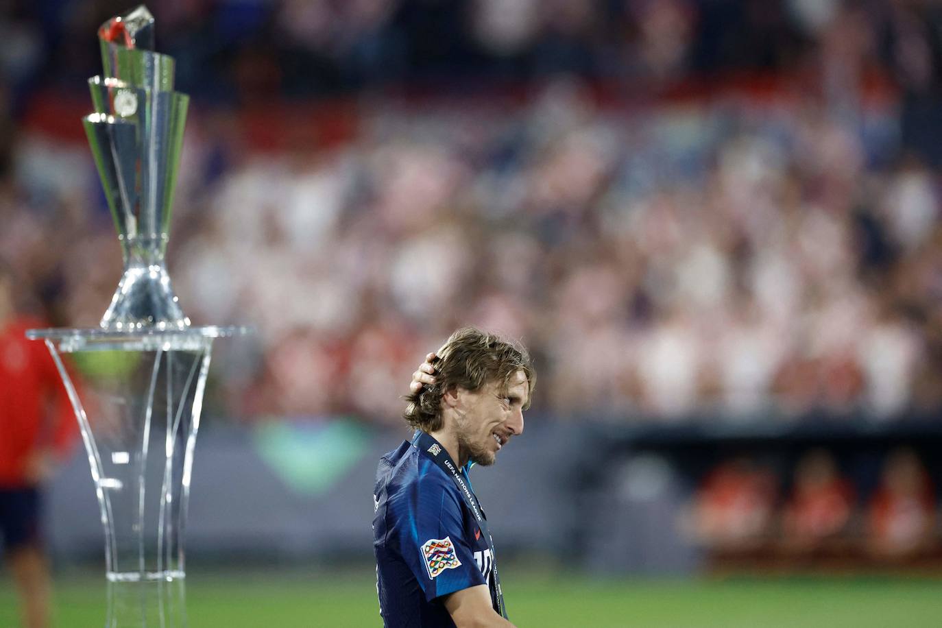 El centrocampista croata Luka Modric reacciona mientras pasa junto a la copa de la Liga de Naciones de la UEFA después de perder contra España al final del partido.