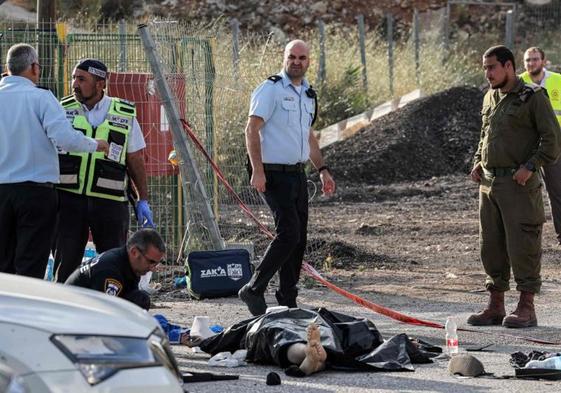 Forenses de la Policía israelí inspeccionan cadáveres tras el ataque ocurrido en el asentamiento judío de Eli, en Cisjordania.