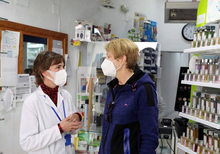 Una farmacéutica y una clienta, en una farmacia de Huelva.