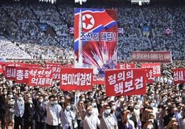 Norcoreanos exhiben pancartas contrarias a EE UU durante la marcha celebrada en Pyongyang.