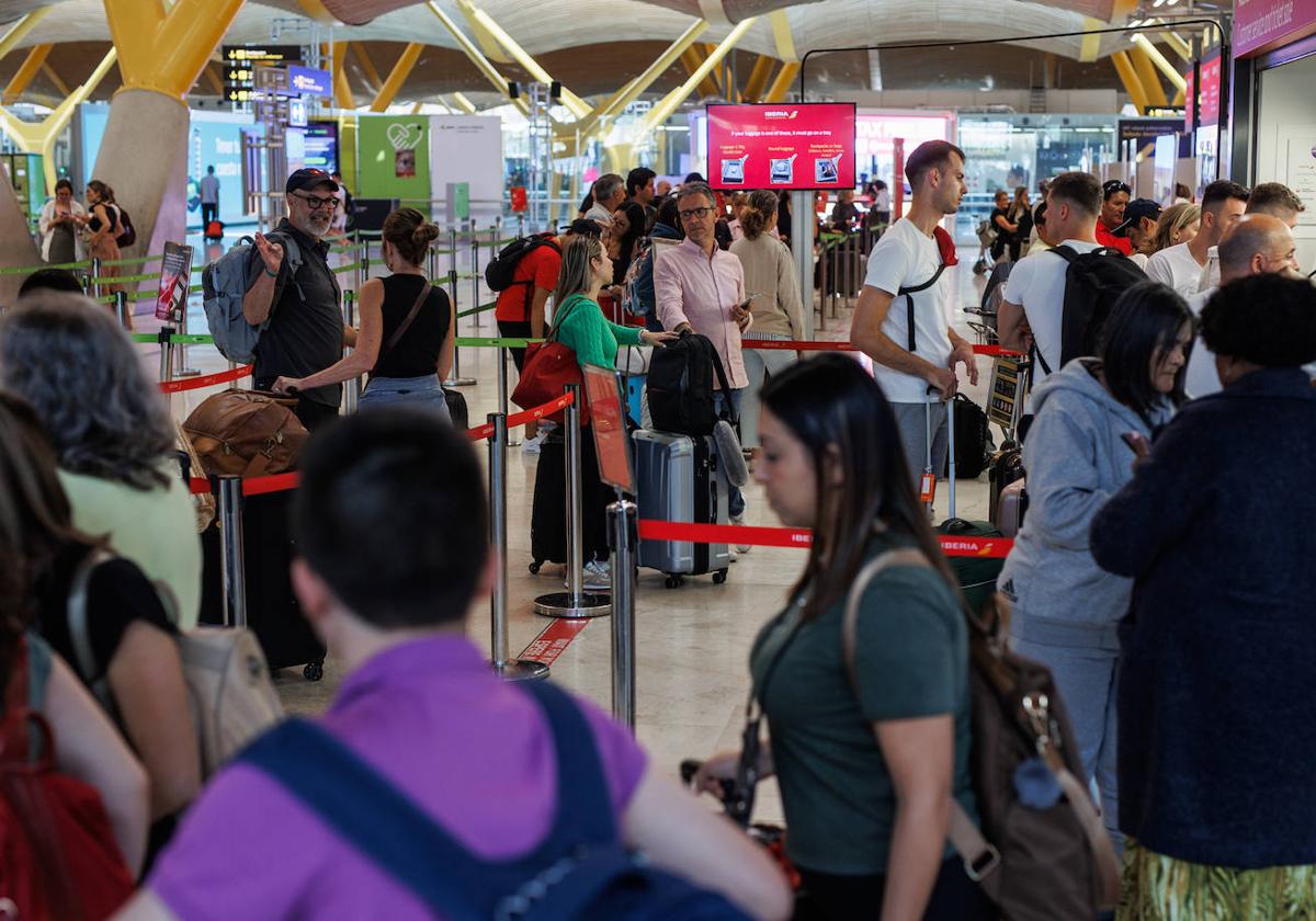 Varias personas hacen cola en la terminal T4 del aeropuerto Adolfo Suárez-Madrid Barajas.