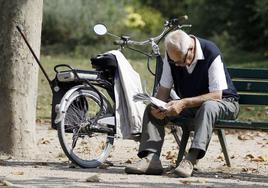 Un jubilado leyendo el periódico en un parque.