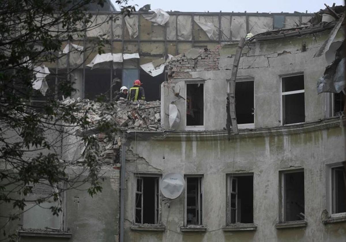 Los bomberos buscan posibles víctimas entre los restos de uno de los edificios atacados.