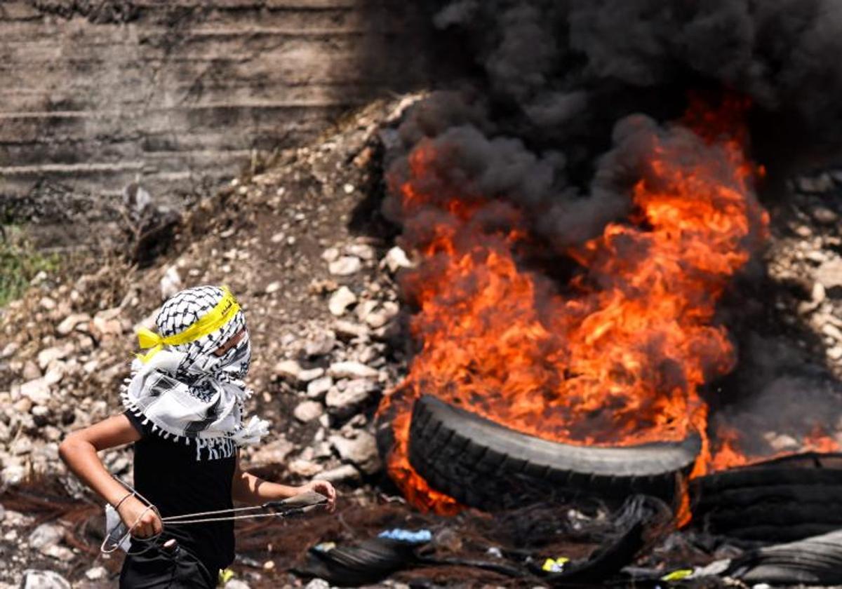 Un manifestante palestino arroja una piedra a soldados israelíes durante una manifestación en Cisjordania.