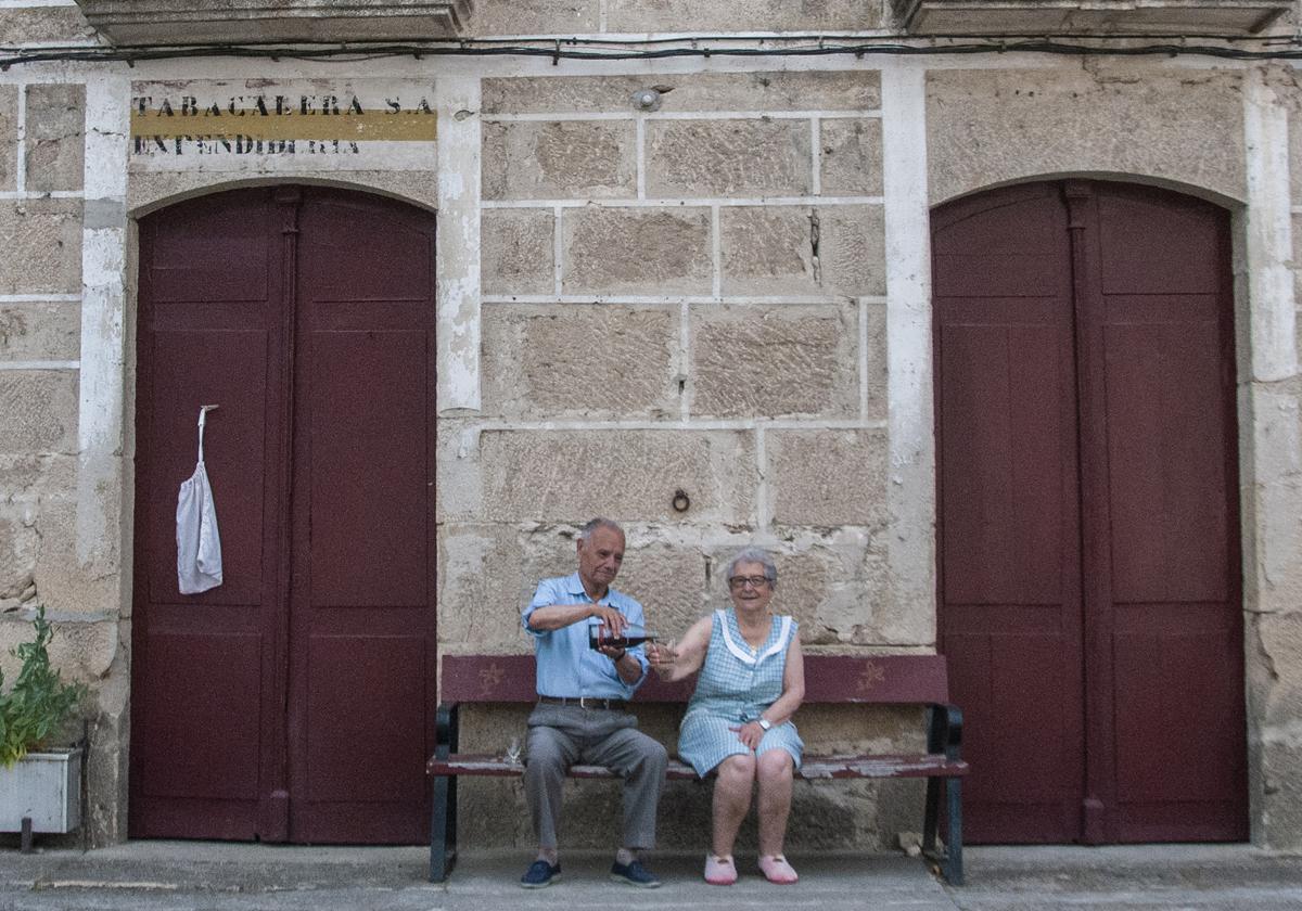 Emilio sirve un licor café a Rosa delante de su casa, donde creció Feijóo y tenía tienda su abuela.