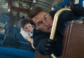 Tom Cruise y Hayley Atwell, como Ethan y Grace, aferrados a un tren que se desploma.