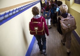 Un grupo de escolares camina por el pasillo hacia su clase.