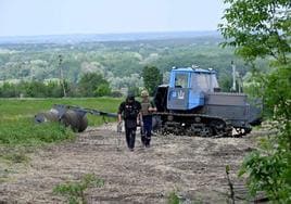 Dos artificieros ucranianos examinan un camino en busca de minas en la localidad de Balakliya, dentro de la región de Járkov.