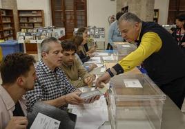 Un cartero entrega el voto por correo en una mesa electoral.