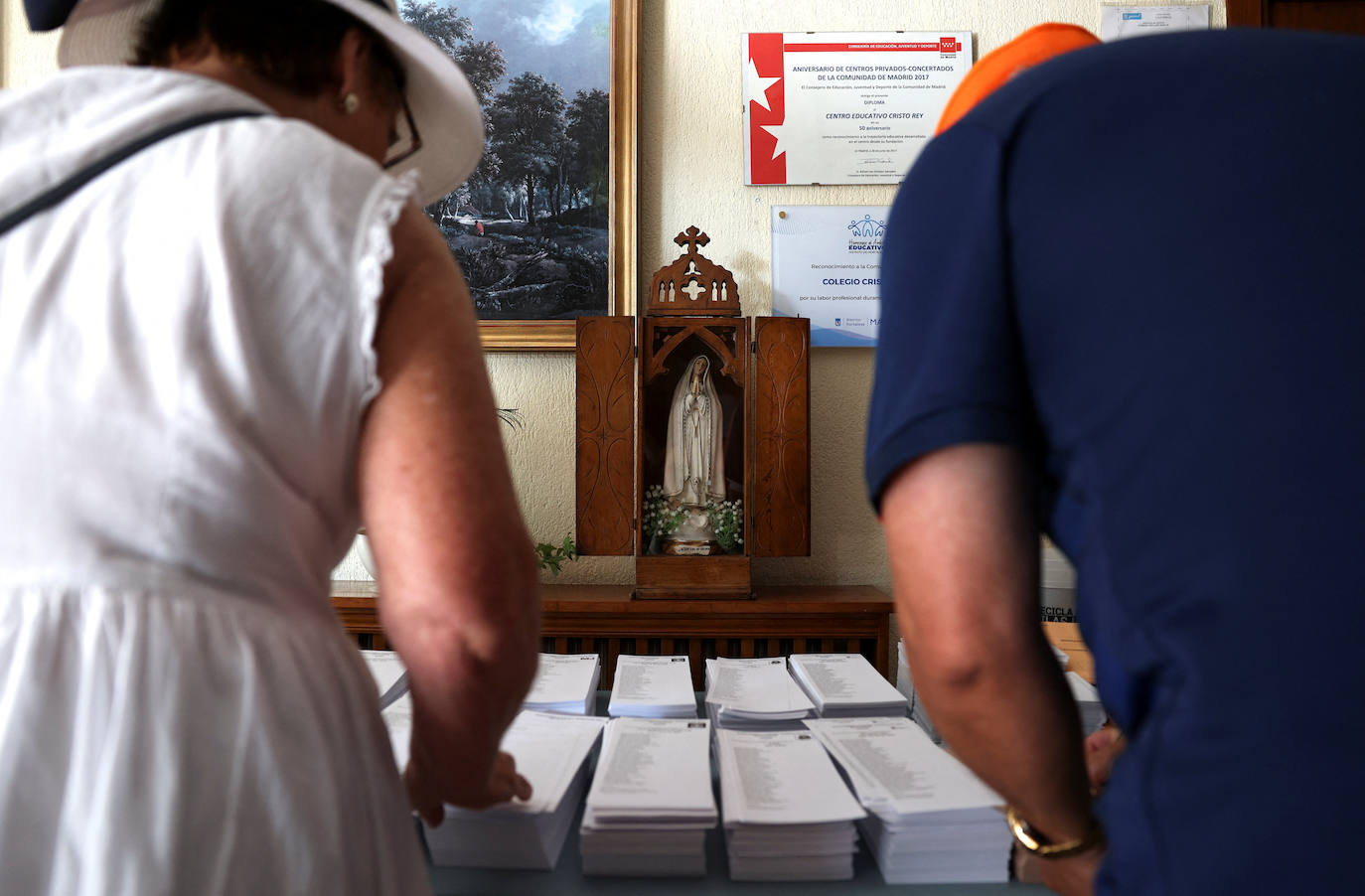 La gente recoge papeletas para votar el día de las elecciones generales anticipadas en un colegio electoral. 