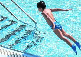 Un niño salta a una piscina.