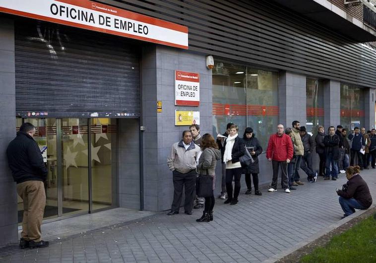 Un grupo de personas esperando que abra la oficina de empleo.