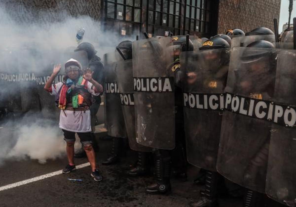 Policías antidisturbios bloquean el paso a una manifestante durante una protesta en Lima.