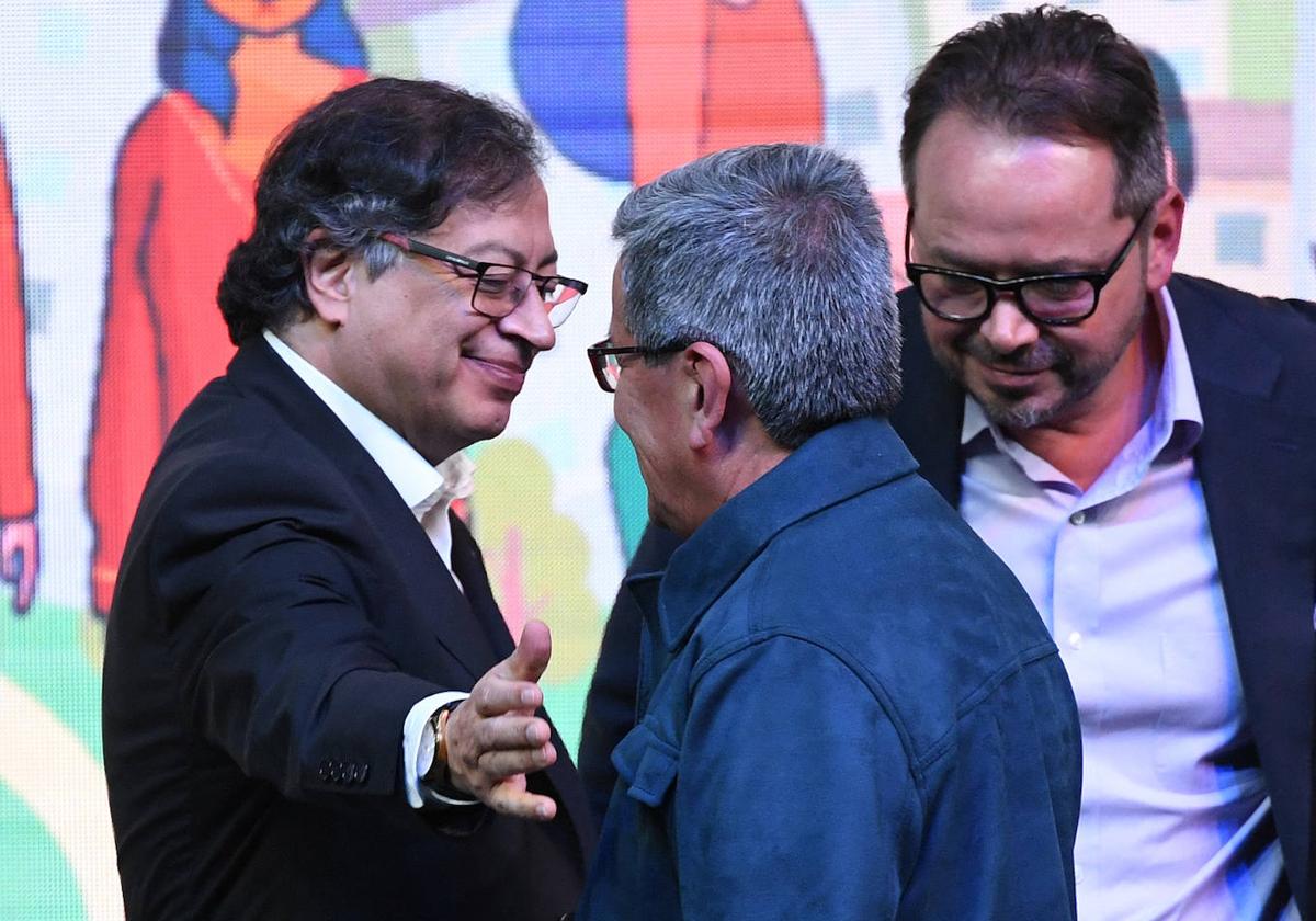 El presidente colombiano, Gustavo Petro, y el jefe del ELN, Pablo Beltrán, se saludan en un acto por el inicio del cese al fuego armado.