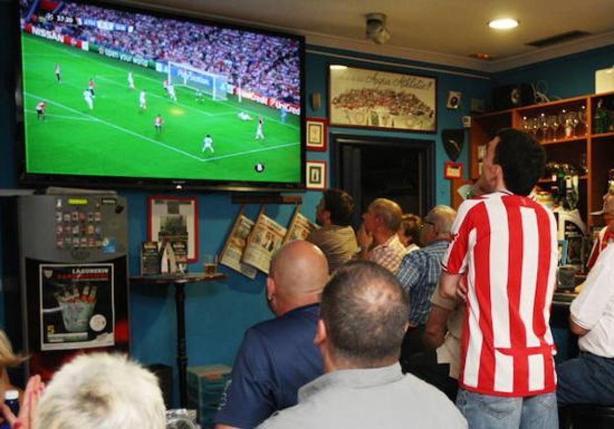 Imagen de archivo de aficionados viendo fútbol en un bar