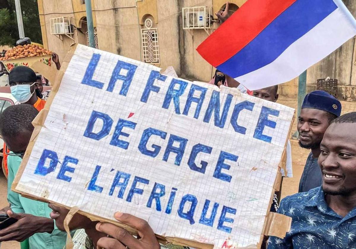 Manifestantes a favor de los golpistas en Niamey, Níger, con una bandera de Rusia y un carten en el que se lee: «Francia fuera de África».