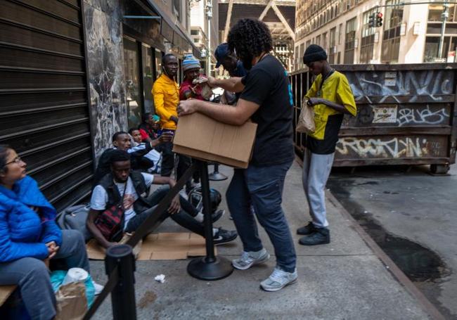 Un hombre reparte alimentos a indocumentados.