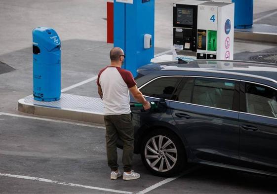 Un hombre reposta carburante en una gasolinera.