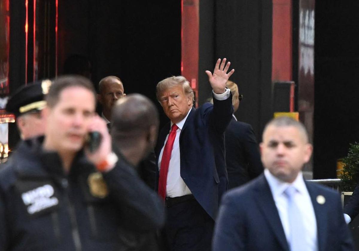 Donald Trump saluda al llegar a la Torre Trump en Nueva York