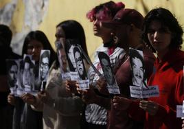 Varias personas sostienen pancartas, con imágenes de exestudiantes de la Universidad de Chile, víctimas de desaparición forzada