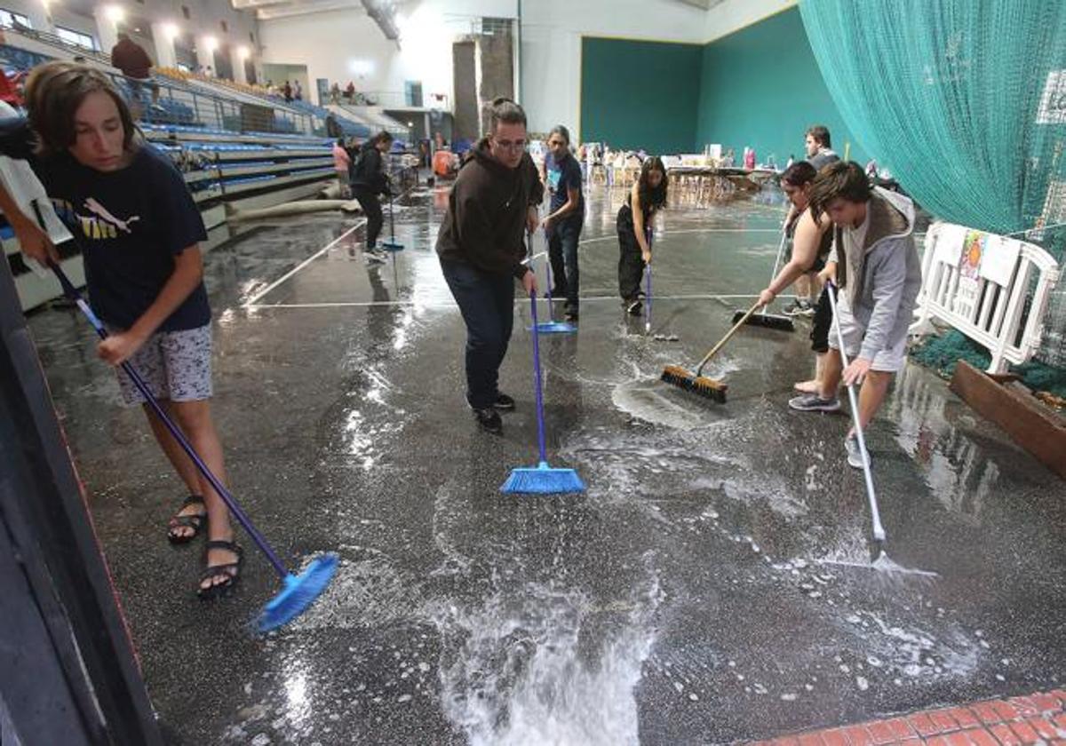 Voluntarios trabajan para desalojar el agua en un polideportivo de Logroño.