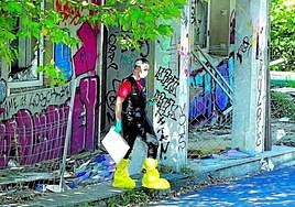 Un investigador policial sale del edificio abandonado de Artxanda en el que fue hallada la maleta en la que apareció el cuerpo.