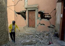 Un joven transita junto a un edificio en riesgo de colapso.