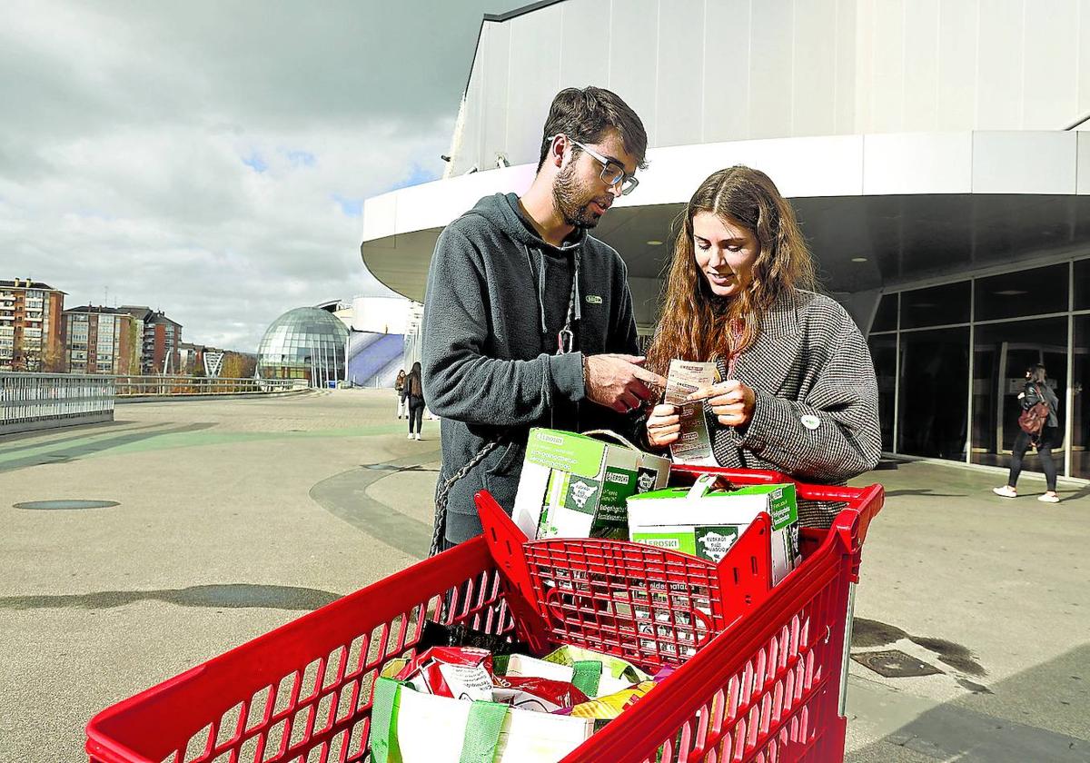 Una pareja revisa el tique de su compra a la salida del supermercado.