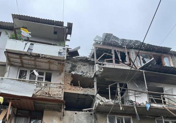 Dos militares caminan frente a un edificio dañado por el ataque de Azerbaiyán en Nagorno Karabaj.