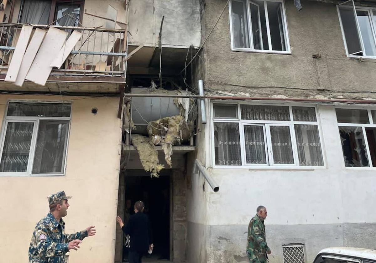 Dos militares caminan frente a un edificio dañado por el ataque de Azerbaiyán en Nagorno Karabaj.