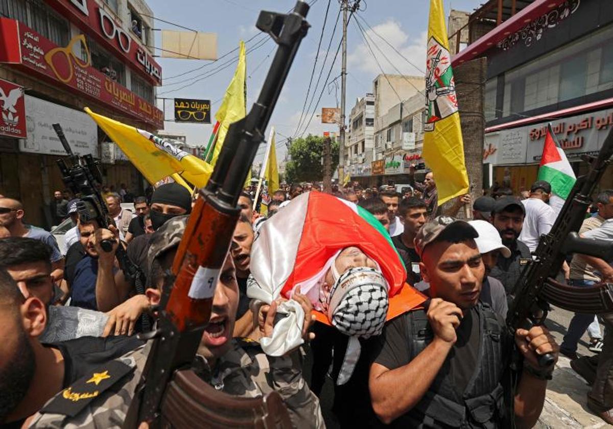 Las milicias palestinas portan el cadáver de una de las víctimas durante el funeral celebrado en Yenin.