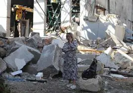 Una mujer habla por teléfono junto a un edificio industrial dañado tras un ataque ruso en la región de Odesa.