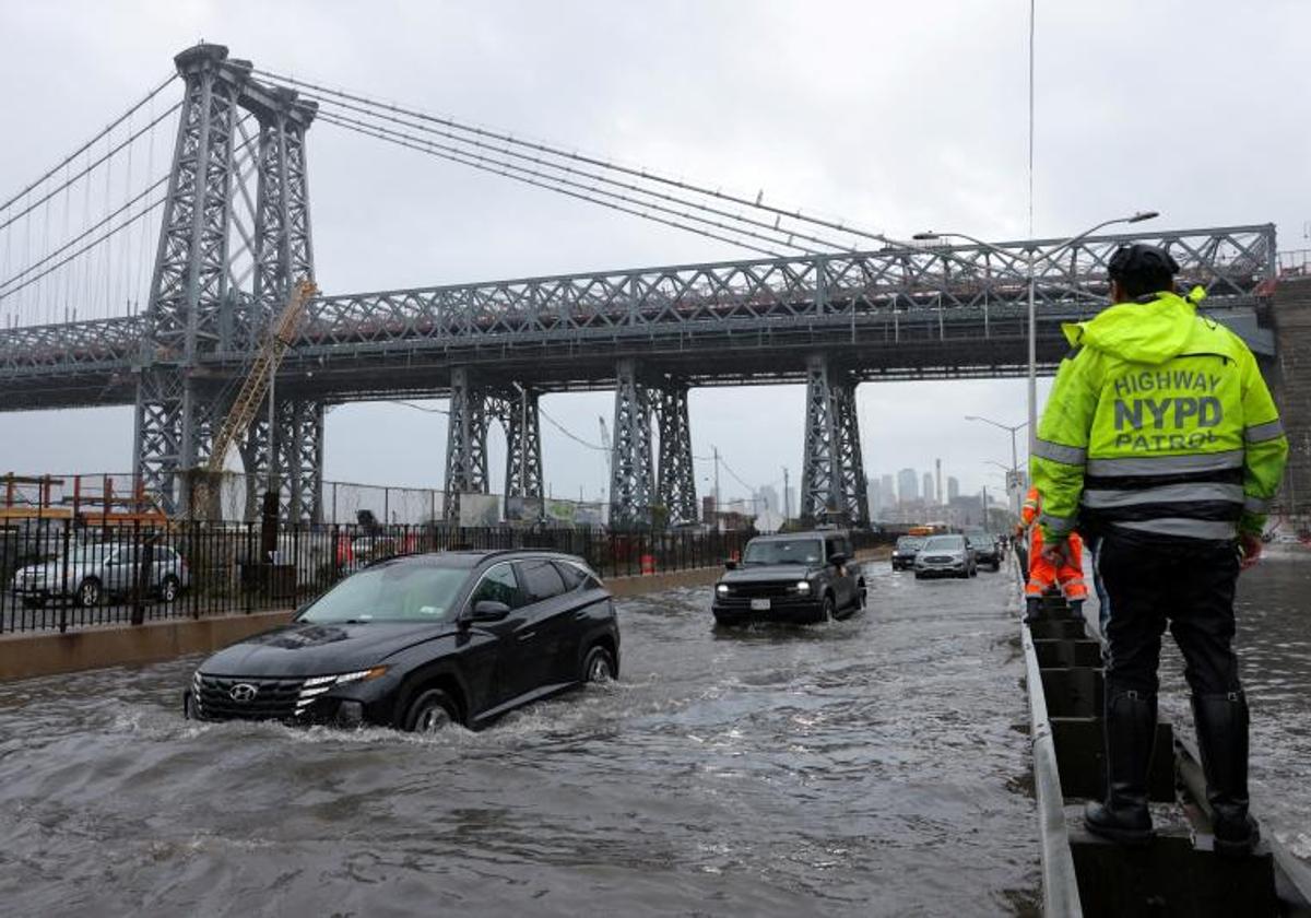 Un oficial controla el tráfico en una calle de Manhattan inundada por las lluvias torrenciales del viernes.