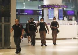 Agentes de policía patrullan dentro del centro comercial Siam Paragon después de que las instalaciones fueran evacuadas por la presencia de unpistolero.