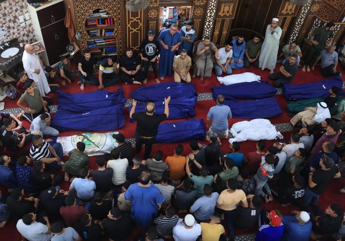 Palestinos se reúnen en una mezquita para rezar sobre los cuerpos de una familia alcanzada por en los ataques israelíes contra la ciudad de Rafah.