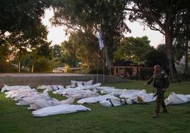 Un militar muestra las bolsas de plástico blanco utilizadas para recoger los cadáveres de los milicianos.