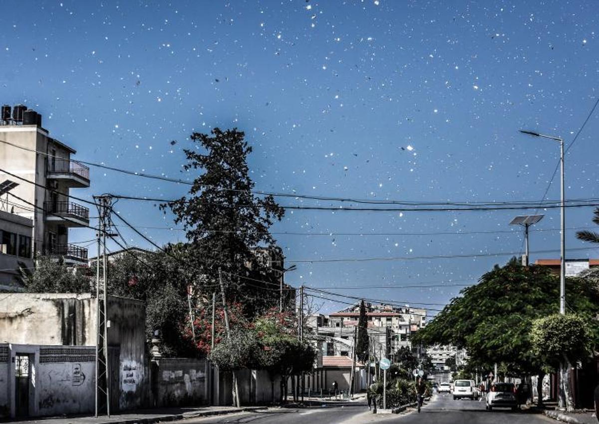 Imagen secundaria 1 - Lluvia de papeles en los que se indica a la población gazatí que abandonen sus casas y el itinerario a seguir.