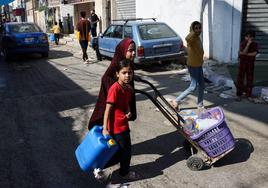 Dos palestinas cargan agua en Rafah.