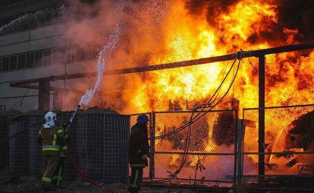 Bomberos apagan las llamas en una central eléctrica de Kiev bombardeada el pasado invierno por Rusia.